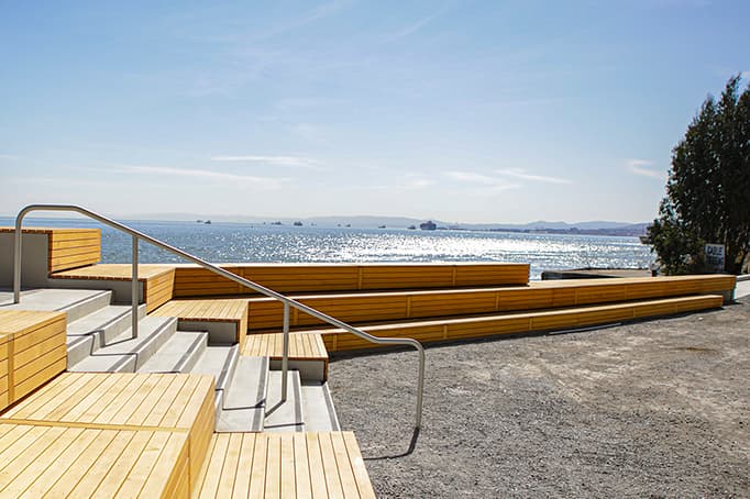 Wooden stepped seating and overlook at Bimla Rhinehart Vista Point, facing the bay on a bright day.