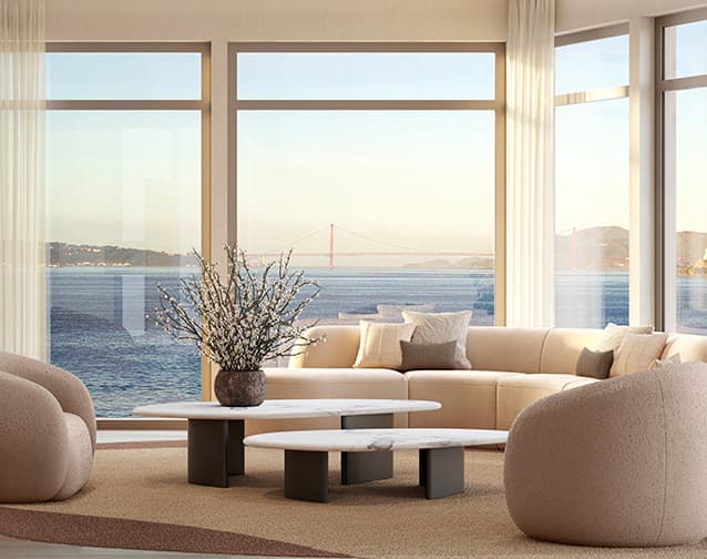 Bright modern living room with floor-to-ceiling windows overlooking the bay and a distant view of the Golden Gate Bridge.